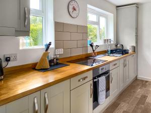 a kitchen with white cabinets and a wooden counter top at The Drive in Newton Reigny