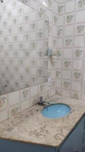 ein Badezimmer mit einem Waschbecken und einer gefliesten Wand in der Unterkunft Hostel Bimba Goiânia - Unidade 02 in Goiânia