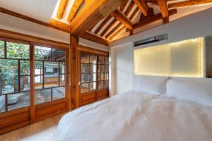 a bedroom with a large white bed and windows at Luxury hanok with private bathtub - SN16 in Seoul
