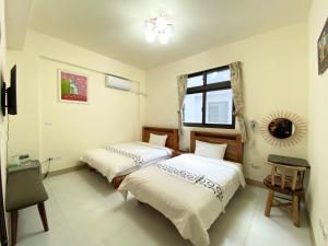 - une chambre avec 2 lits et une fenêtre dans l'établissement Huitaro Homestay, à Yuli