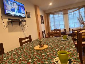 une salle à manger avec une table et une télévision dans l'établissement Posada Sierra Morena, 