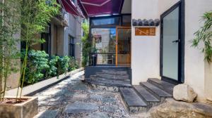 a door to a building with a stone walkway at Gongxili - Chujian Hotel in Kunming