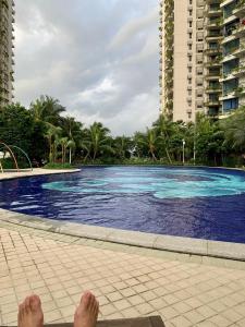 a person laying on the ground next to a swimming pool at Sea view 2 bedroom Fully furnished Apartment Forest City Starview Bay Johor Malaysia in Kampong Pok Kechil