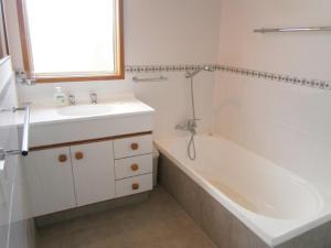 un bagno con vasca, lavandino e vasca da bagno di Baskervilla - Whangamata Holiday Home a Whangamata Altre 8 foto