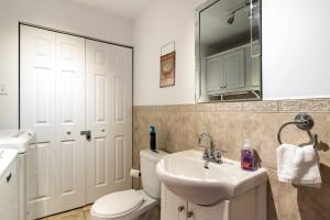 a bathroom with a toilet and a sink and a mirror at Live like a Montrealer in this 3-bedroom home! in Montréal