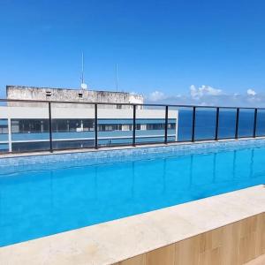 una piscina con el océano al fondo en Barra.Smart, en Salvador
