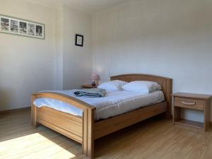 1 dormitorio con cama con marco de madera y mesa en Maison Locoal-Mendon, 4 pièces, 6 personnes - FR-1-397-74, en Locoal-Mendon