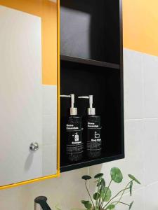 a bathroom with two bottles of hair products in a cabinet at NEW Chic Cosy Sepang KLIA KLIA2 5-7 Pax in Sepang