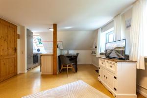 a living room with a table and a television on a dresser at Appartement EBB in Morsum