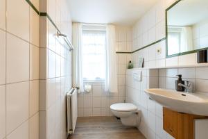 a bathroom with a toilet and a sink at Appartement EBB in Morsum +11 photos