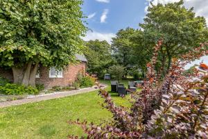 a garden with benches and a brick building at Appartement EBB in Morsum