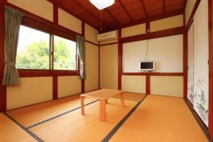 a room with a table and a tv in it at 民宿やまそ in Takashima