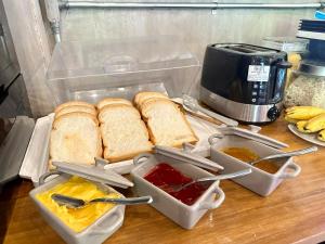 a table with bread and condiments on a counter at The Old Inn in Udon Thani