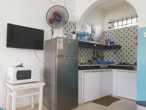 a kitchen with a refrigerator and a microwave at Villa with private pool near sandy beach in Pointe aux Biches