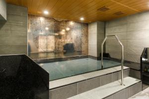 a swimming pool in a room with a wall at Via Inn Shimonoseki in Shimonoseki