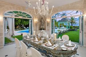 a dining room with a table and chairs and a chandelier at Leamington Pavilion by Blue Sky Luxury in Saint Peter