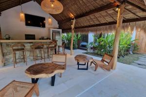 a patio with chairs and a bar in a house at petra bianca uluwatu in Uluwatu