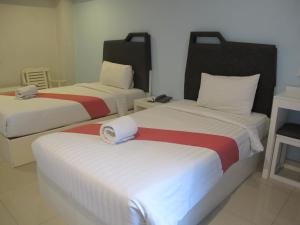 a hotel room with two beds with red and white sheets at Sunny Residence in Lat Krabang