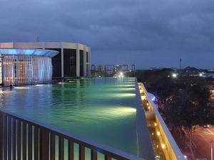 een groot zwembad 's nachts voor een gebouw bij Twin Eleven in Kota Bharu