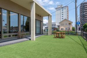 un patio con mesa y sillas en un edificio en AOI Sauna SPA & Dog Villa HAKODATE, en Hakodate