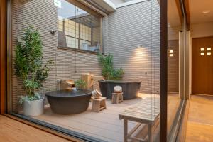 函館市にあるAOI Sauna SPA & Dog Villa HAKODATEのバスルーム(バスタブ2つ、鉢植えの植物付)