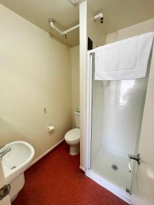 a bathroom with a shower and a toilet and a sink at Stay Hostel Rotorua in Rotorua