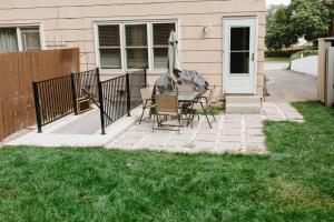 un patio con una silla y una sombrilla en una casa en Feeling Home, while away, en Kitchener