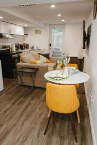 a kitchen and living room with a table and yellow chairs at Feeling Home, while away in Kitchener