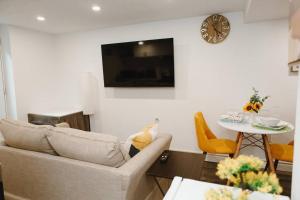 a living room with a couch and a table with a clock at Feeling Home, while away in Kitchener