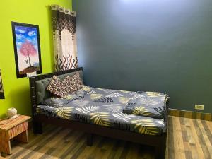 a bed in a room with a green wall at Ghar-fully furnished house with 2 Bedroom hall and kitchen in Bangalore