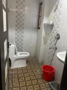 a bathroom with a toilet and a sink and a bucket at Ghar-fully furnished house with 2 Bedroom hall and kitchen in Bengaluru