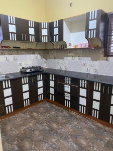 uma cozinha com armários de madeira e uma bancada em Ghar-fully furnished house with 2 Bedroom hall and kitchen em Bangalore