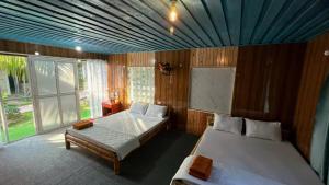 a bedroom with two beds and a blue ceiling at Phu Nam House - Resort in Phú Quốc
