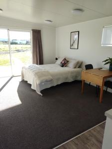 ein Schlafzimmer mit einem großen Bett und einem Schreibtisch in der Unterkunft Studios On Carroll - ex Ferry Hotel in Wairoa