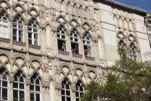 La gente mira por las ventanas de un edificio en Pal's Hostel and Apartments, en Budapest