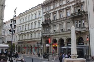 una calle de la ciudad con edificios y una fuente frente a un edificio en Pal's Hostel and Apartments, en Budapest