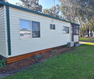 Una casa blanca con una ventana en el costado. en Island Leisure Village, en Bobs Farm