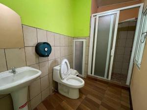 a bathroom with a toilet and a sink at Hotel del Carmen in Retalhuleu