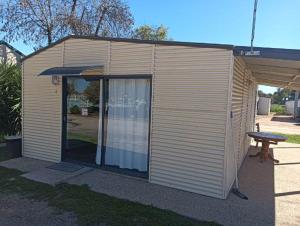 a small building with a picnic table in front of it at Sunraysia Holiday Park in Mildura