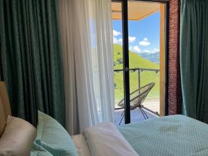 una camera con letto e vista su un balcone di Luxury apartment with specticular views a Gudauri