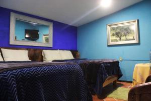 1 dormitorio con 2 camas y pared azul en habitación en medio de la naturaleza en Zacatlán