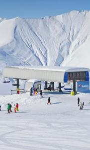 grupa ludzi w śniegu w pobliżu wyciągu narciarskiego w obiekcie Luxury apartment with specticular views w mieście Gudauri