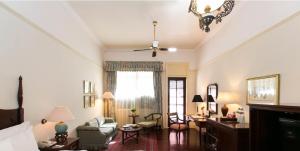 a living room with a ceiling fan and a living room at Hotel Majapahit Surabaya MGallery in Surabaya