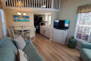 a living room with a couch and a table with a tv at Kokomo! - Tiny House with Boat Lift, Waterfront, Tiki in Jewfish