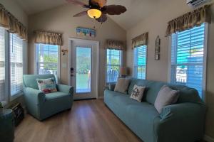 un soggiorno con divano blu e ventilatore di Kokomo! - Tiny House with Boat Lift, Waterfront, Tiki a Jewfish