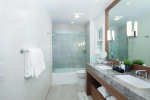 uma casa de banho com 2 lavatórios e um chuveiro em Carmel Beach Hotel em Carmel