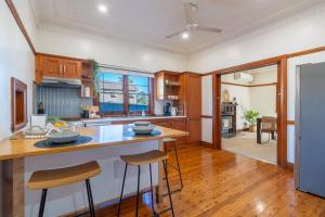 a kitchen with wooden cabinets and a counter with stools at Bali Huts in Nowra
