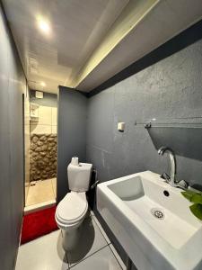 Un baño con un inodoro blanco y un lavabo. en Kahea Ragni, en Punaauia 16 fotos más