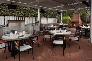 a restaurant with tables and chairs and a fireplace at Carmel Beach Hotel in Carmel