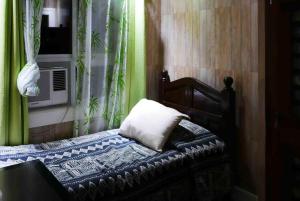 - une chambre avec un lit doté d'un oreiller et d'une fenêtre dans l'établissement JMTヴィラ, à Dinalupihan